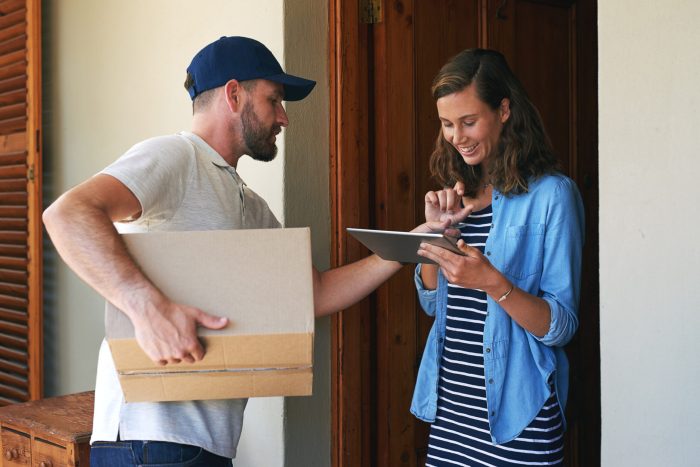 Woman, delivery man and box with tablet for ecommerce order, parcel or cargo in transport service. Female person receiving shipment from male courier, supply chain or online purchase at front door.